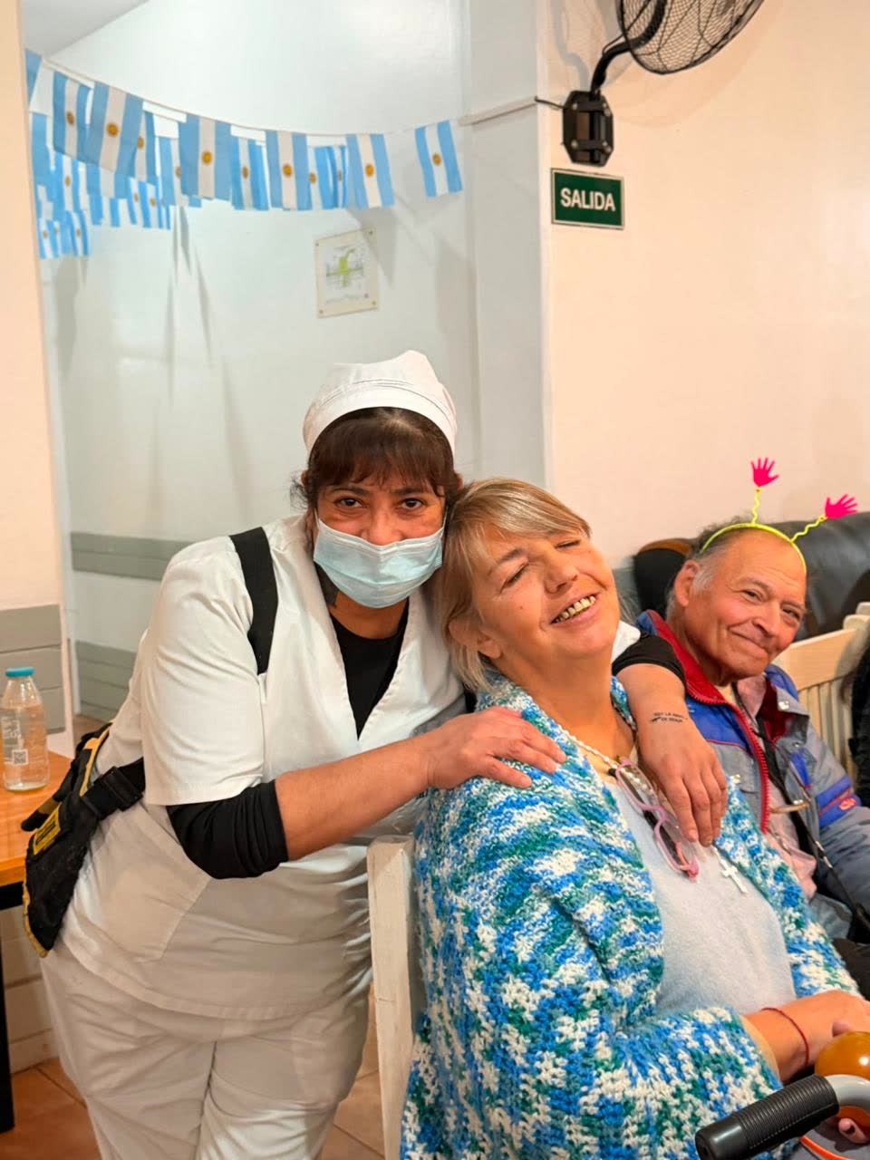 Asistente del hogar abrazando a una residente sonriente